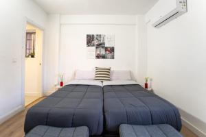 ein großes Bett in einem weißen Zimmer mit 2 Stühlen in der Unterkunft ModernCozy apartment near Barajas in Madrid