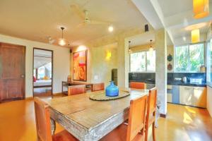 una cucina e una sala da pranzo con tavolo e sedie in legno di Sovi - Luxury apartments with pool near Mandrem beach north Goa a Mandrem