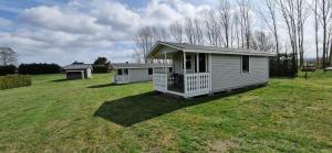 una pequeña casa en un campo con un patio en Ängdala Camping på Österlen, en Kivik