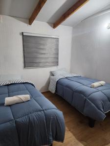 a bedroom with two beds and a window at Cabañas MAWEN in Chaitén