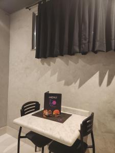 a laptop sitting on a table with two chairs at Motel Só Love 3 in Sao Paulo
