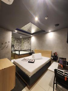 a bedroom with a large bed and two chairs at Motel Só Love 3 in Sao Paulo