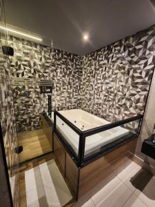 a bath tub in a bathroom with a stone wall at Motel Só Love 3 in Sao Paulo