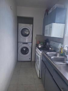 uma cozinha com uma máquina de lavar roupa e uma máquina de lavar roupa em Impeccable Comfortable 1-Bed Apartment em Road Town