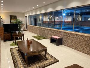 a lobby with a swimming pool in a building at منتجع ريف خزيمة - الياسمين in Al Madinah