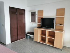 a room with a television on a desk with a door at Súper PENT-HOUSE ACAPULCO!! in Acapulco