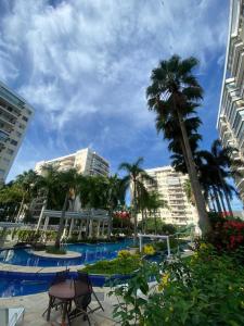 a resort with a pool and palm trees and buildings at Barra Family Resort, a sua melhor escolha in Rio de Janeiro +26 photos