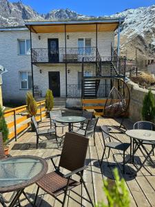 un patio avec des tables et des chaises en face d'un bâtiment dans l'établissement Guesthouse Elia, à Kazbegi