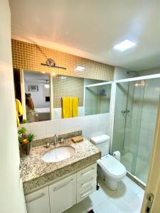 a bathroom with a sink and a toilet and a mirror at Barra Family Resort, a sua melhor escolha in Rio de Janeiro