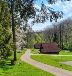 a barn in a park with a path at Záruby Resort in Smolenice