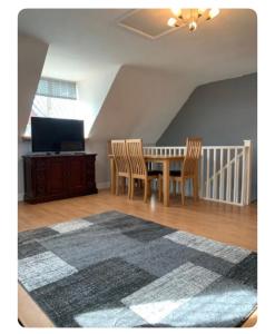 a dining room with a table and chairs and a television at The Little House, Oswestry in Chirk