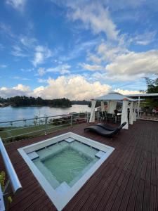 a hot tub on a deck with a view of the water at Hotel Bania travels in Guatapé