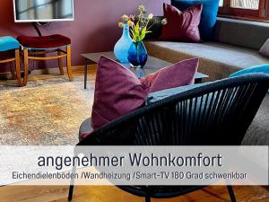 salon z kanapą i stołem z fioletowymi poduszkami w obiekcie Maisonette-Wohnungen "Beim Schmied" im Chiemgau w mieście Traunreut