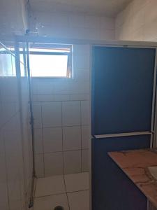 a bathroom with a shower with a blue door at Assel Xaxim AP1 Curitiba in Curitiba