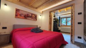 ein Schlafzimmer mit einem großen roten Bett in einem Zimmer in der Unterkunft Casetta Vanda in Santo Stefano di Cadore