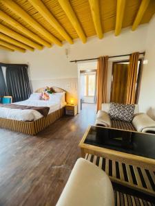 Habitación grande con 2 camas y sofá en Guza Ethnic Resort en Leh