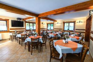 Un restaurante con mesas y sillas y un televisor de pantalla plana. en Willa Kubik, en Zakopane