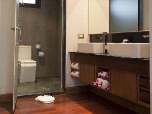 a bathroom with a vanity with two sinks and a mirror at The Nchantra Beachfront Resort in Phuket Town