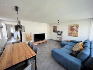 - un salon avec un canapé bleu et une table en bois dans l'établissement Grand appartement lumineux avec terrasse, à Courcouronnes