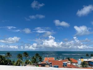 a view of the ocean with buildings and palm trees at Flats e Suítes Elcaline in Porto De Galinhas