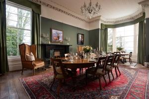 a dining room with a table and chairs and a fireplace at Cairnbank House & Garden Apartment in Duns