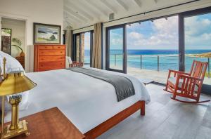 a bedroom with a bed and a view of the ocean at Oil Nut Bay in Virgin Gorda