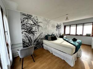 - une chambre avec un lit et un mur orné d'une fresque murale dans l'établissement Grand appartement lumineux avec terrasse, à Courcouronnes