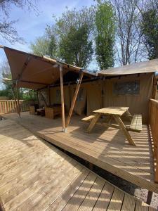 a tent with a picnic table on a deck at Heated & brand new Forestlodge in Renesse