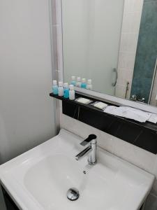 y baño con lavabo blanco y espejo. en Pera Hotel Baku, en Baku