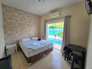 a bedroom with a bed and a large window at Pousada Santa Gianna in Aparecida