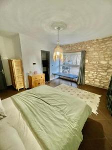 ein großes Bett in einem Schlafzimmer mit einer Steinmauer in der Unterkunft Chill House surf camp in Sidi Kaouki
