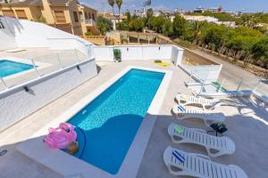 einen Pool mit Liegestühlen und einem Pool in der Unterkunft Fidalsa Grand Mediterranean Beachfront in Playa Flamenca