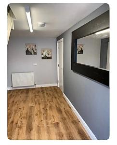 un soggiorno con un grande specchio e pavimenti in legno di The Little House, Oswestry a Chirk