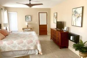 a bedroom with a bed and a flat screen tv at Heated Saltwater Pool Home Minutes to Beach in Englewood