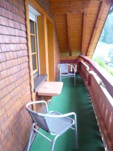 2 sillas y una mesa en el balcón en Gästehaus Maria Brinkhus, en Schonach
