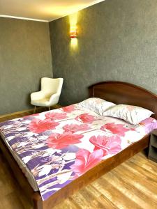 um quarto com uma cama com um edredão floral em 2-к Люкс в центре em Cherkasy