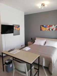 - une chambre avec un lit, un bureau et un lit dans l'établissement Passione mare, à Trapani