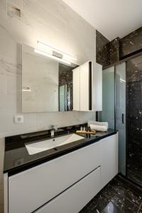 a white bathroom with a sink and a shower at FN Suites in Monolithos