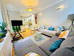 a living room with a couch and a table at Cozy and Comfy flat in Earls Court in London