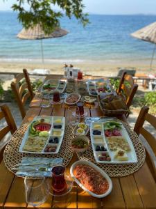 a table with plates of food on the beach at Denizevi Karvunyi in Marmara Adasi +40 photos