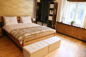 a bedroom with a large bed with a bench in it at The Tranquil Retreat Countryside Escape in Larkhall