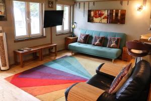 sala de estar con sofá y alfombra colorida en The Retreat Tranquil Countryside Apartment, en Larkhall