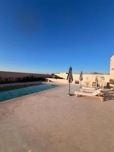 un resort con piscina, sedie e ombrellone di Marrakech LUXURY VILLA a Marrakech