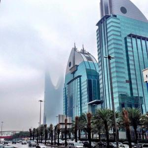 Al Anoud Tower Residence في الرياض: مدينة فيها مباني طويلة و نخيل و سيارات