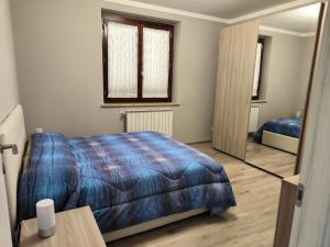 a bedroom with a blue bed and a mirror at Casa di Sabrina in Fabro +3 photos