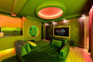 a living room with green furniture and a kitchen at L’Insolite, Spa Privatif (Appartement Jacuzzi) in Toulouse
