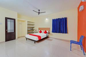 um quarto com uma cama e uma cadeira em Flagship Maxworth em Chennai