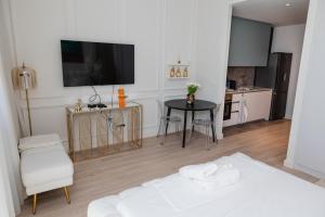 Una habitación con una cama y una mesa y una cocina. en Studio Passion-Belgrade Waterfront, en Belgrado