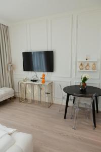 ein Wohnzimmer mit einem Tisch und einem Flachbild-TV in der Unterkunft Studio Passion - Belgrade Waterfront in Belgrad