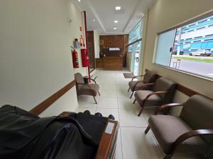 a waiting room with chairs and a corridor at Pousada Santa Gianna in Aparecida